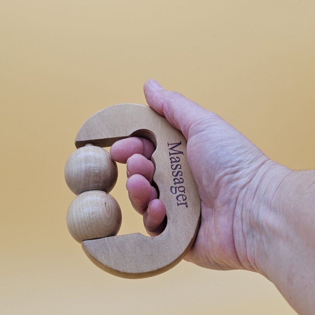 Mano sosteniendo masajeador facial